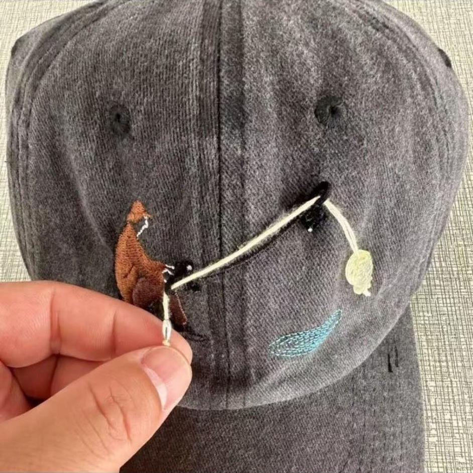 Casquette de pêche à broderie interactive devant charbon de bois